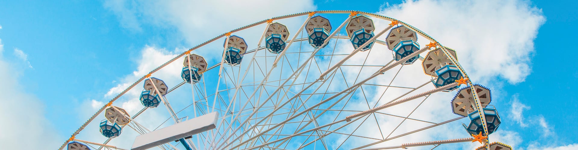 Colorful ferris wheel in an amusement park against blue sky